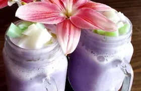 A fresh fruit smoothie made at Pada Thai, served in a mason jar and garnished with a lily